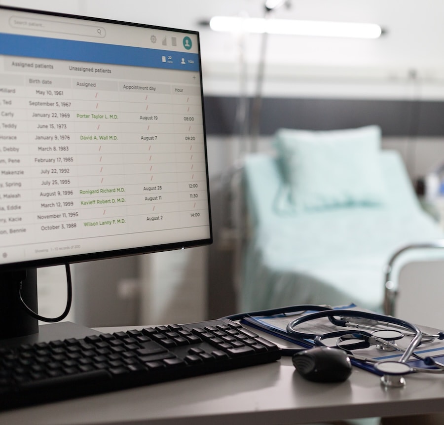 A patient record open on a monitor beside a hospital bed