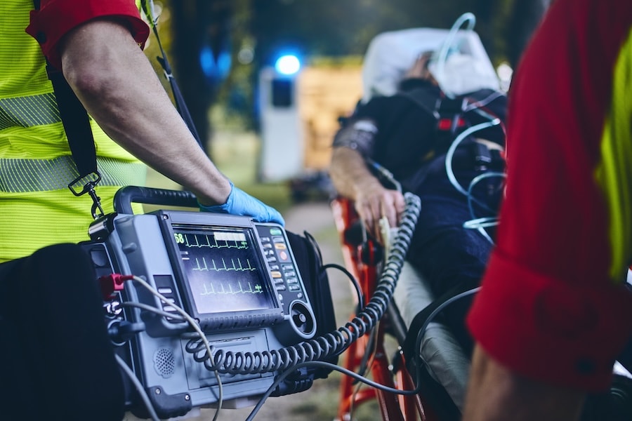 Emergency responders using a defibrillator monitor on a patient